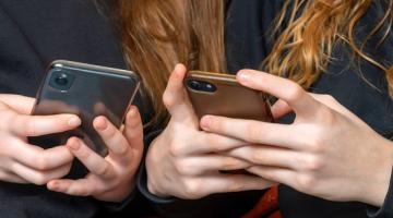 2 young people holding mobile phones